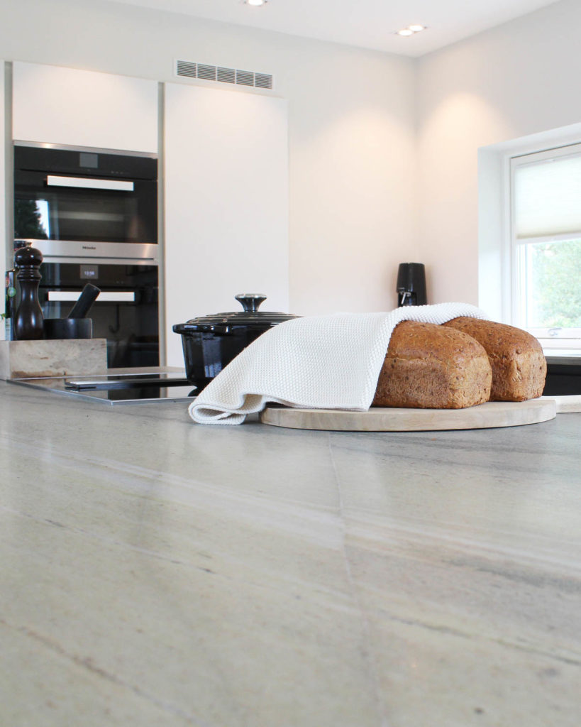 Close-up of slate worktop. A couple of freshly baked breads are on the natural stone countertop.