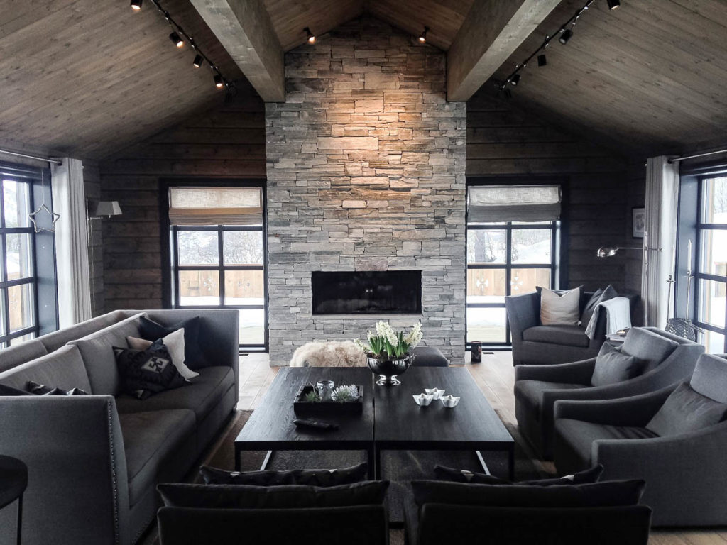A bright living room in a cabin with a slate fireplace of Light Oppdal slate drywall bricks. In front of the fireplace it is furnished with a sitting area.