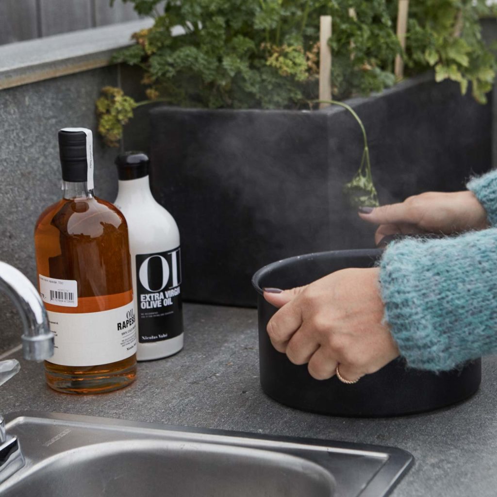 Detail picture of outdoor kitchen with a natural stone countertop of Oppdal slate in an outdoor kitchen. A hot saucepan is placed directly on the worktop.