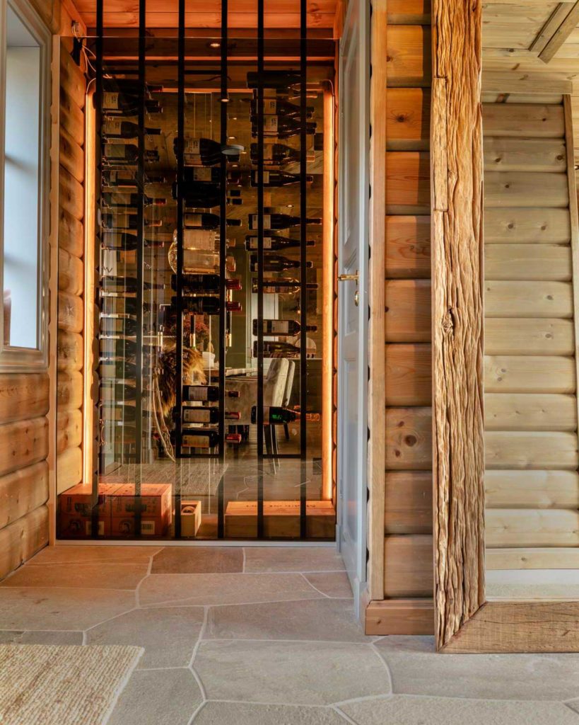 En hall med oregelbunden skiffer på golvet och med tillgång till vinskåp med glasväggar.