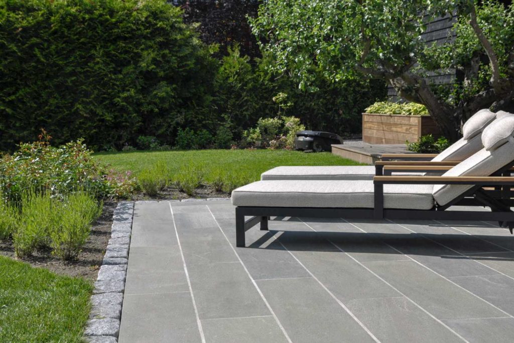 2 modern sun loungers on a terrace covered with outdoor tiles in Oppdal quartzite slate.