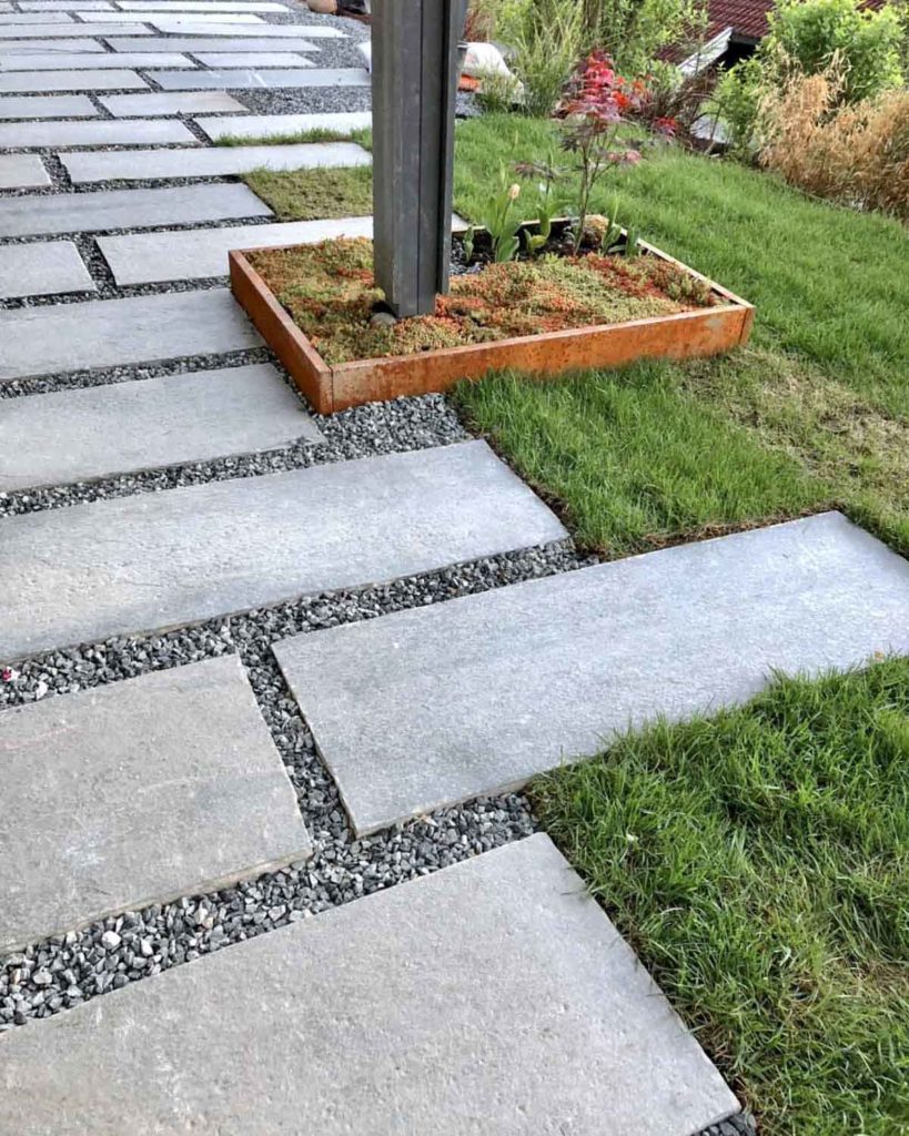 A footpath of stepping stones in atural stone. The  Oppdal quartzite slate slabs are laid in a pattern with gravel in between.