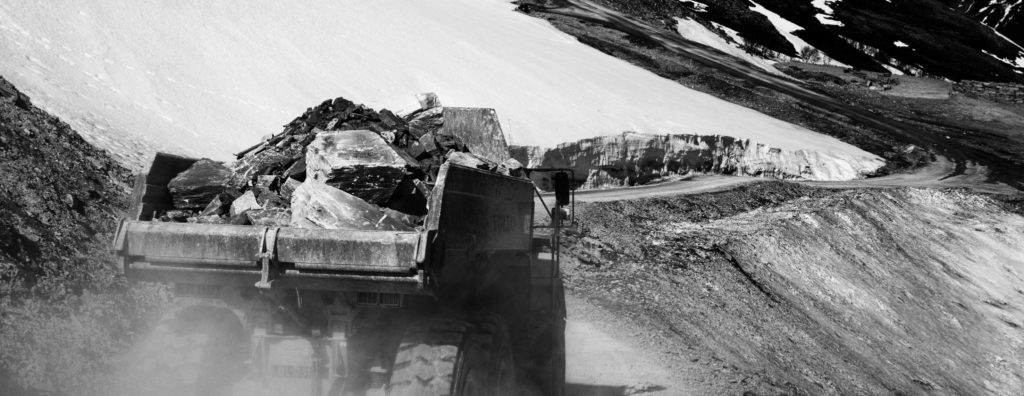 En hjullastare lastad med skifferblock som kör en slingrande väg från stenbrottet i Oppdal.