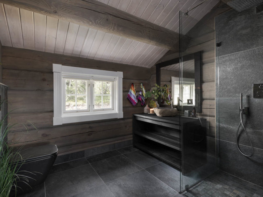 Inspirasjon hyttebad: mørke skiferfliser kombinert med tømmer, mørkt interiør og friske planter. 