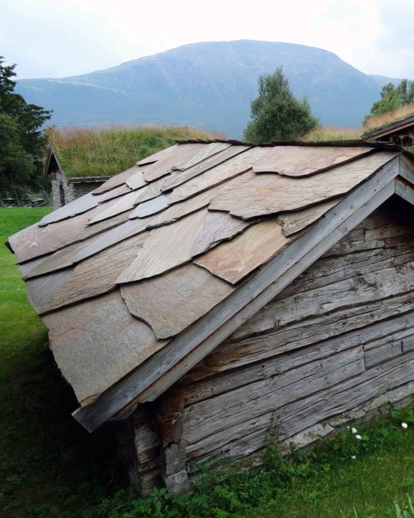 An old farmhouse with an old slate roof of Otta Pillarguri flagstone. The slate roof is rust-colored.