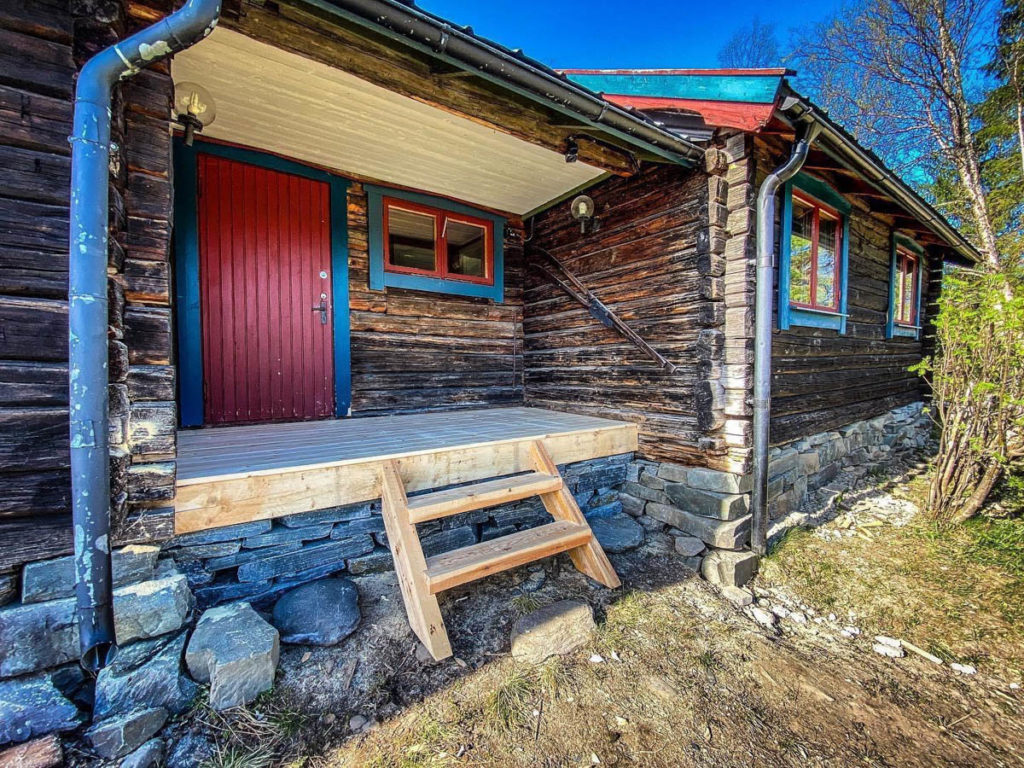 An old log house that has been given a slate foundation wall of brick from Offerdal.