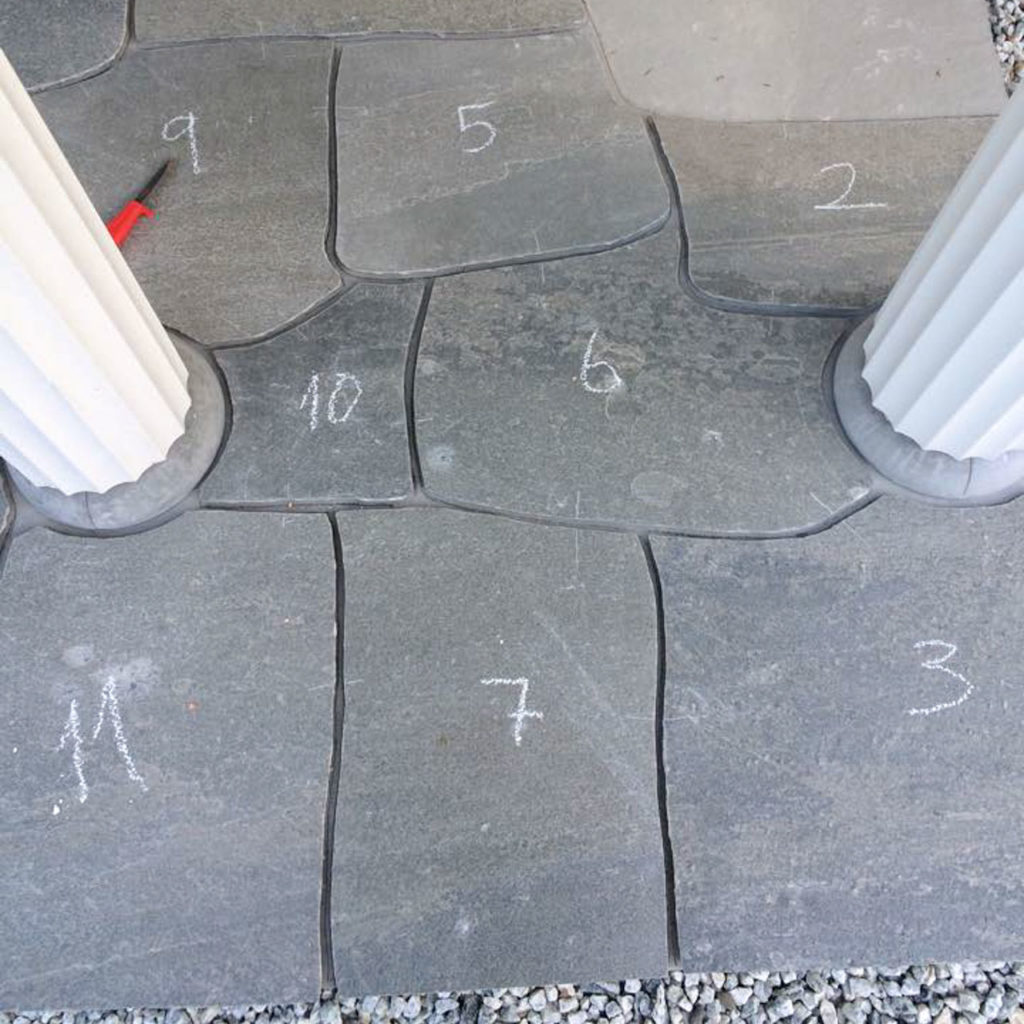 A patio with flagstones that are finished shaped and adapted with a slate scissors. The Oppdal slate is numbered and about to be glued.