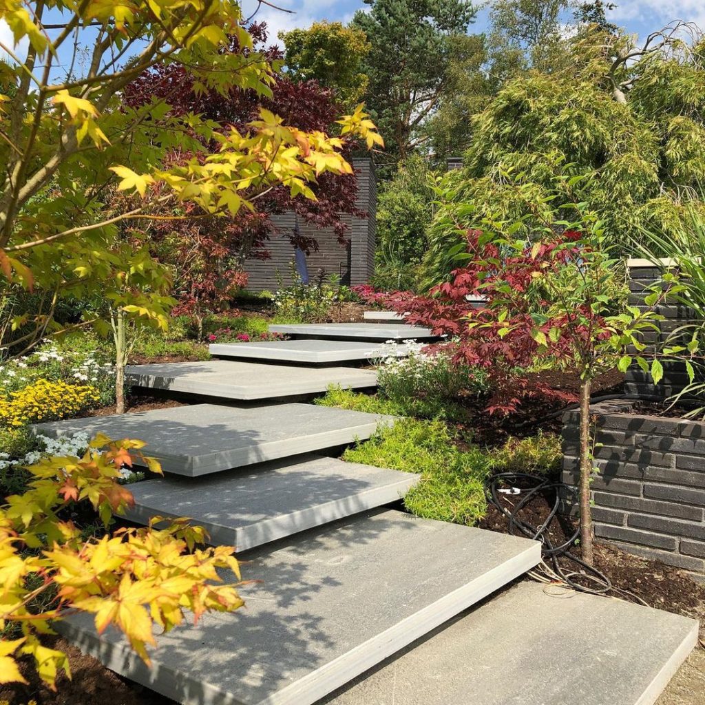 A natural stone staircase in a garden with large steps in Oppdal quartzite. The slate slabs are laid with an overlap upwards like a terrain staircase.