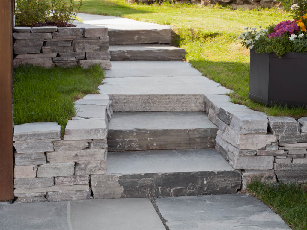 A garden with steps of slate and a low dry wall of slate bricks.