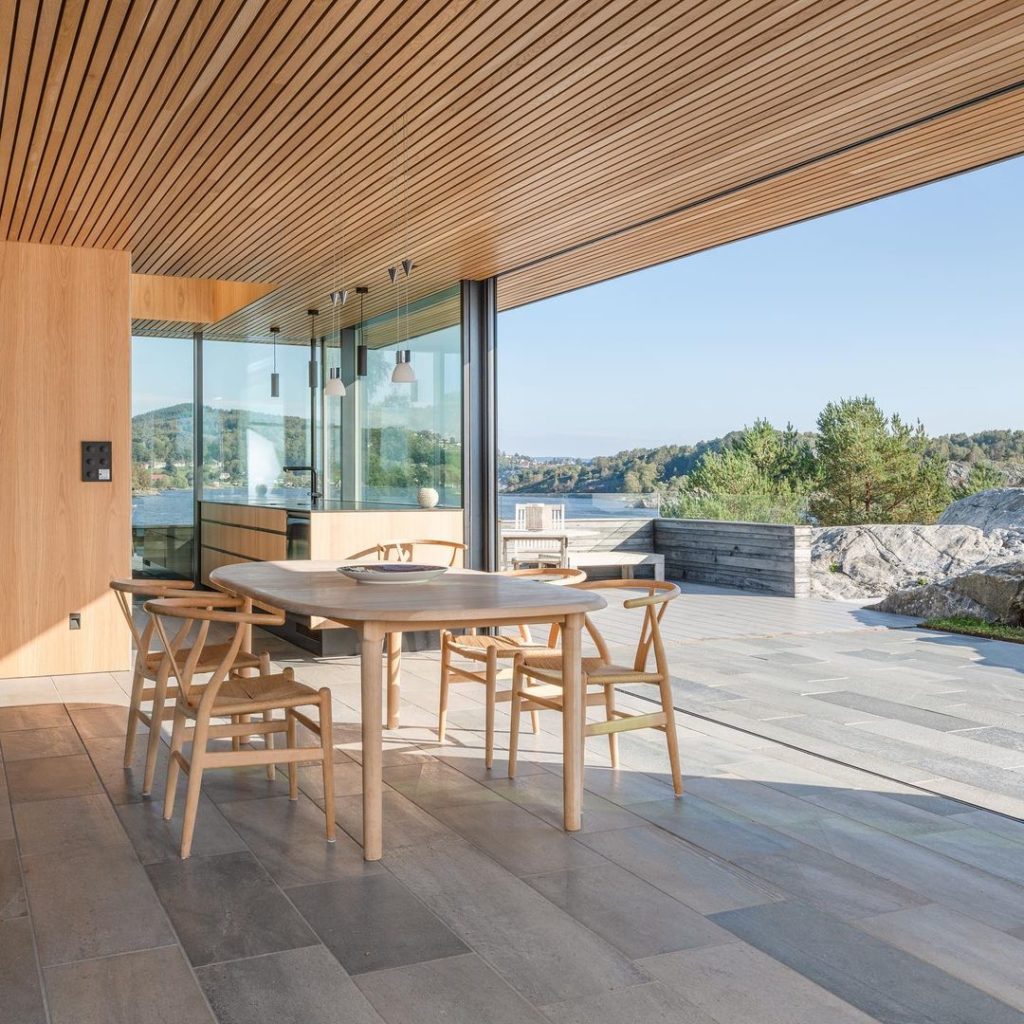 A modern cottage by the sea. Light Oppdal quartzite slate tiles are laid both on the terrace and inside the dining room. 