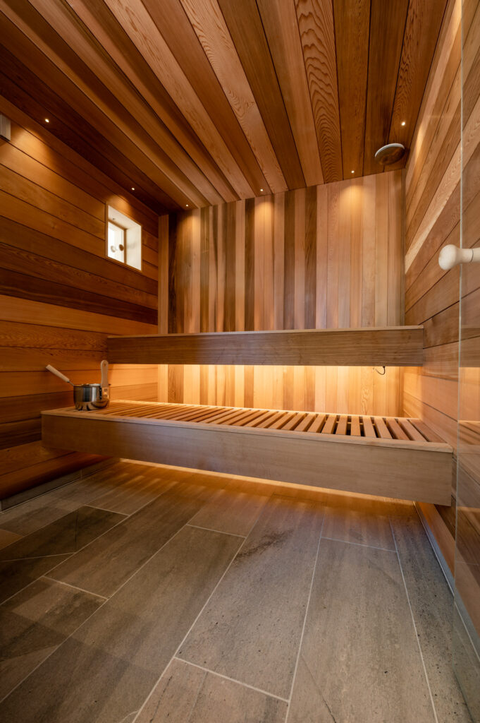 En badstu med skiferfliser på gulv og panel av sedertre på veggene.