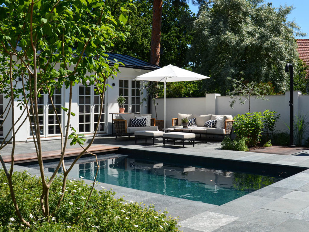 A patio with pool and outdoor shower. The terrace is covered with slate outdoor tiles from Offerdal.
