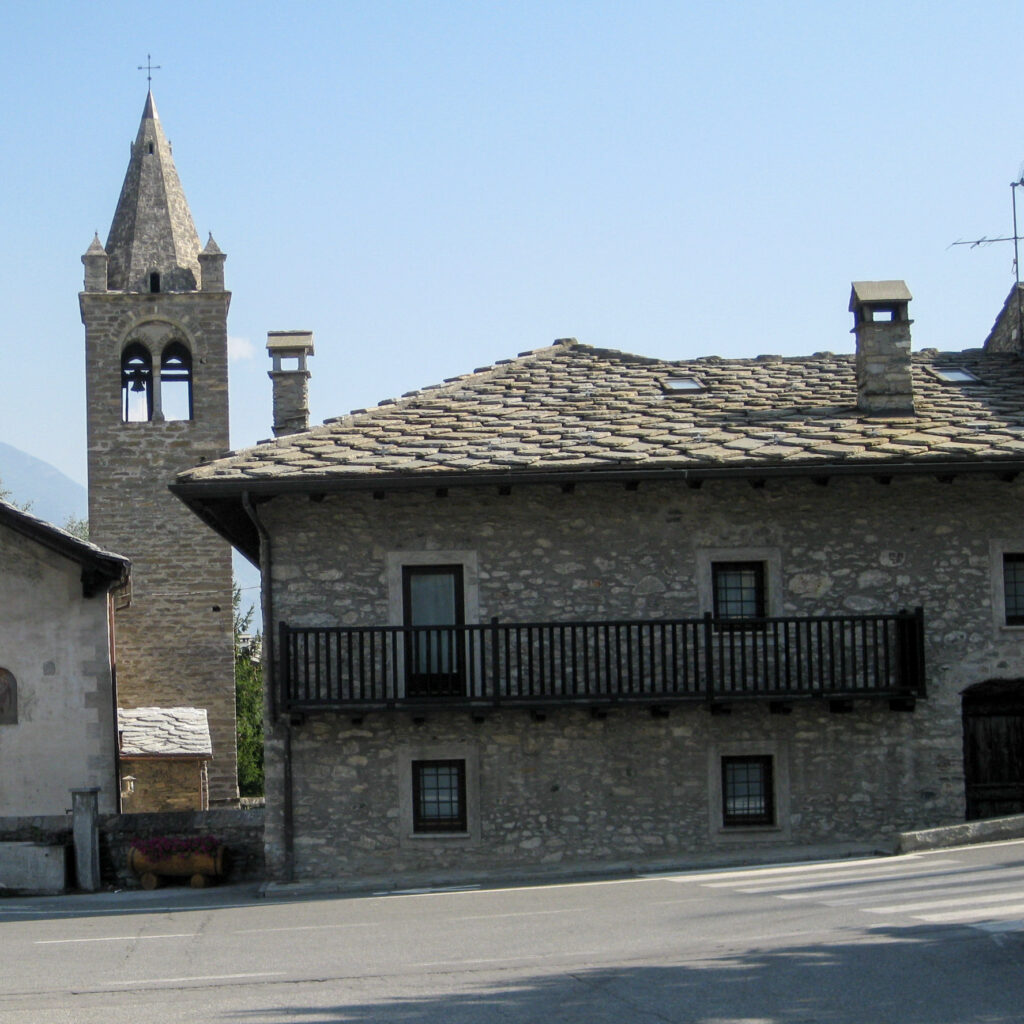 Et  hus med skifertak og et klokketårn i en italiensk by 