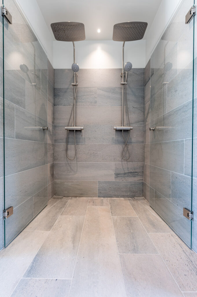 A double shower with tiles on the floor and wall in Oppdal light gray slate tiles