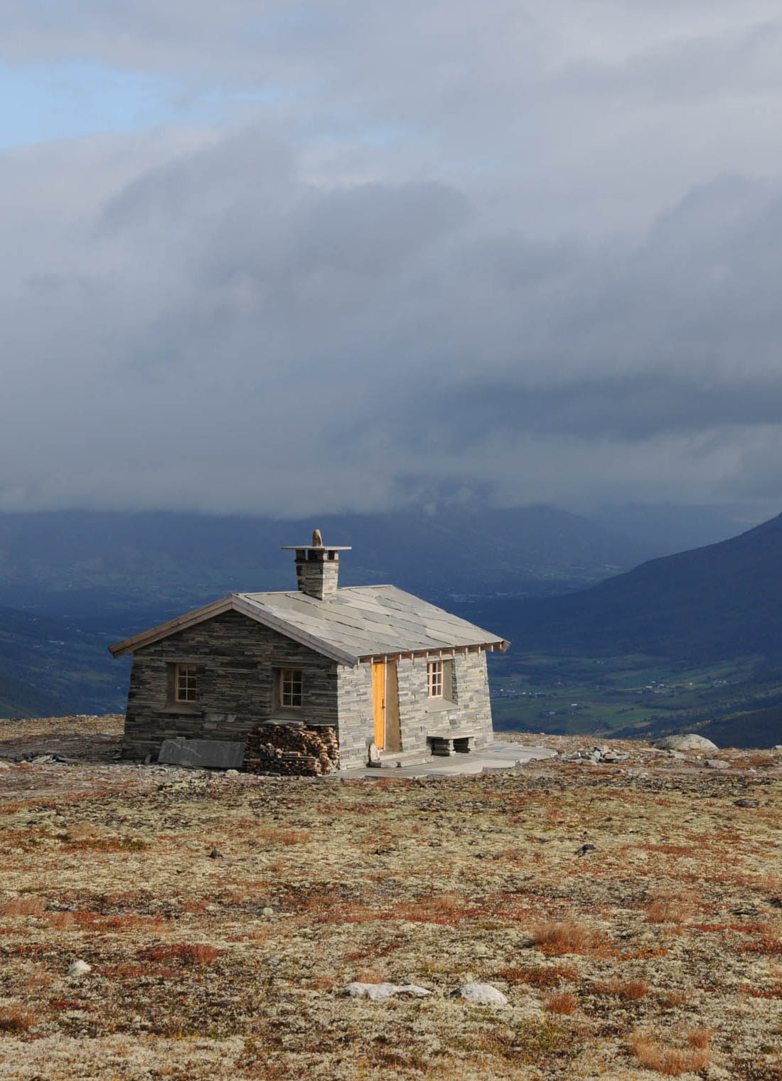 Hytte på Sæterfjellet med utsikt over dalen. Hytta er kledd i fasadeskifer.